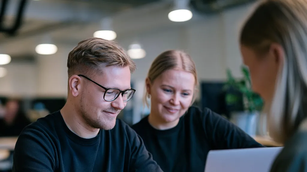 Reaktin asiantuntijat käymässä läpi asiakaskokemuksen mittareita kannettavalta tietokoneelta
